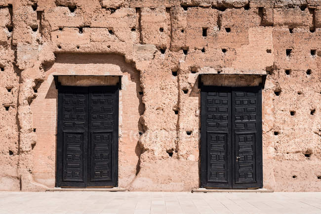 Detalle de puertas de madera en muro de piedra en Marruecos - foto de stock