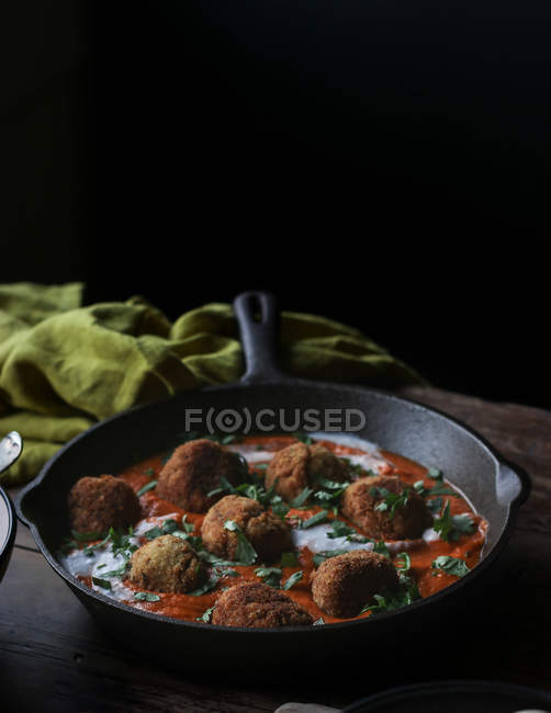 Pan with cauliflower and quinoa balls in sauce on wooden table — Stock Photo