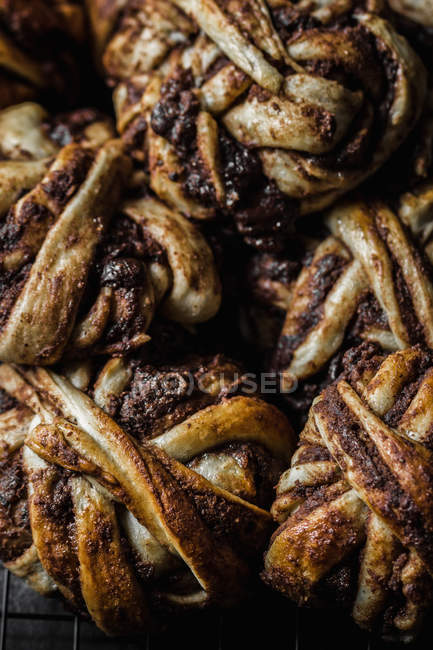Tas de délicieux petits pains au chocolat sur grille métallique — Photo de stock