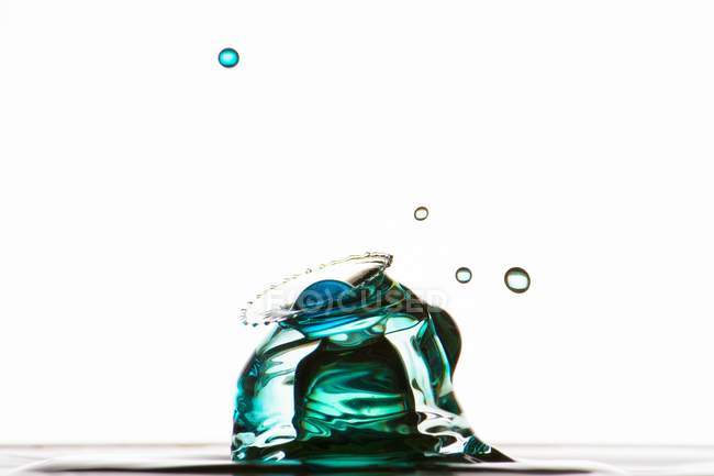 Closeup shot of splash of colorful transparent liquid on white background — Stock Photo