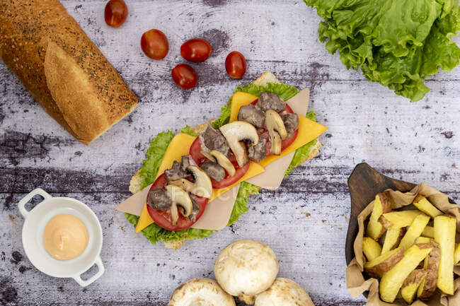 Dall'alto vista di piatti agricoli con verdure e pane messi in ordine su sfondo di legno — Foto stock
