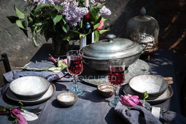Спорудження столової плити з артечоксом, квітами і червоним вином. — стокове фото
