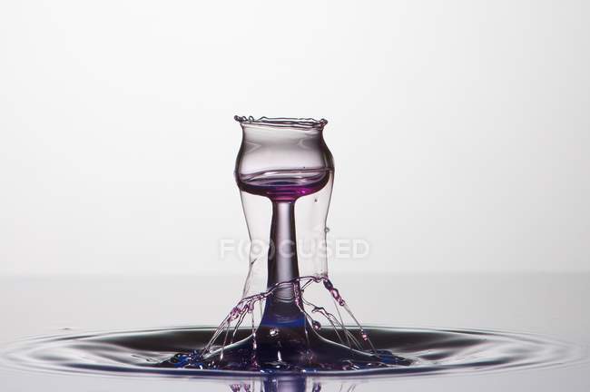 Splash of transparent liquid of color on white background — Stock Photo