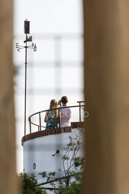 Вид ззаду на невпізнавану пару, що стоїть на даху і приймає селфі з фотоапаратом — стокове фото