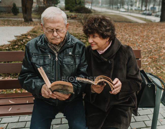 Couple aîné lisant des livres dans le parc — Photo de stock