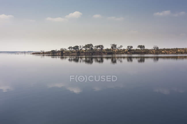 Великолепный вид на озеро со спокойной водой и далеким побережьем в удивительный пасмурный день в Португалии — стоковое фото