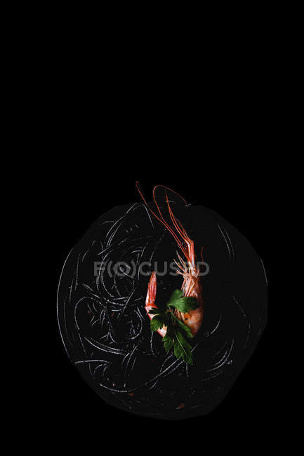 Macarrão preto com camarão servido em fundo preto — Fotografia de Stock