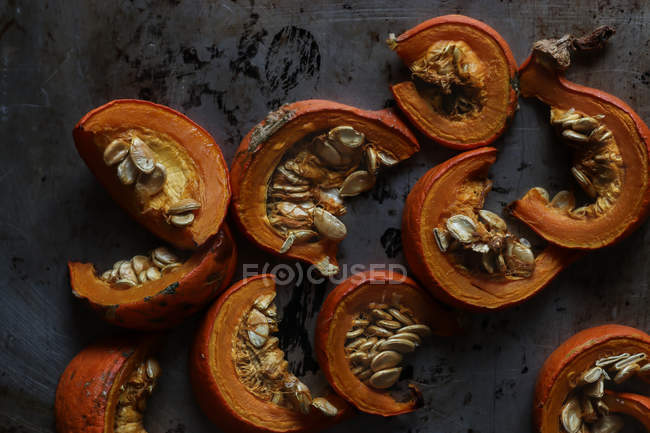 Slices of roasted pumpkin on dark surface — Stock Photo