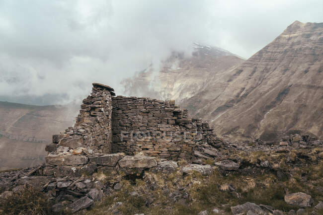 Кирпичное строительство вблизи вершины горы между облаками — стоковое фото