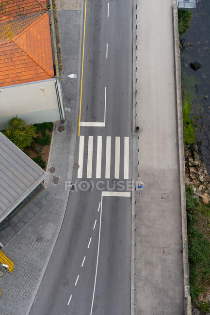 Сверху асфальтовый маршрут с пешеходным переходом между проходом и старыми зданиями в Порту, Португалия — стоковое фото