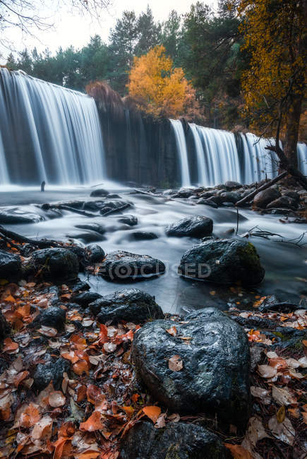 Vue pittoresque cascade d'eau et feuillage forestier d'automne à Presa del Pradillo, Rascafria, Espagne — Photo de stock