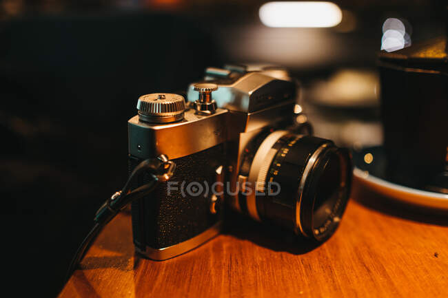 Retro câmera de fotos deitado na mesa de madeira no café elegante — Fotografia de Stock