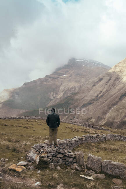 Чоловік стоїть на скелі на горі — стокове фото