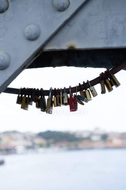 Verschiedene Vorhängeschlösser an einer Brücke über dem Fluss in Porto, Portugal — Stockfoto