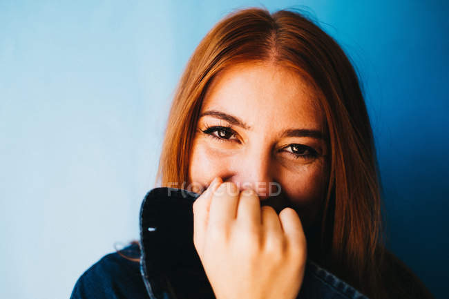 Привлекательная женщина стоит у голубой стены — стоковое фото