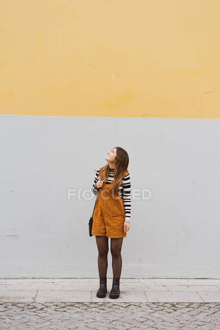 Jovem mulher sorridente perto de parede cinza — Fotografia de Stock