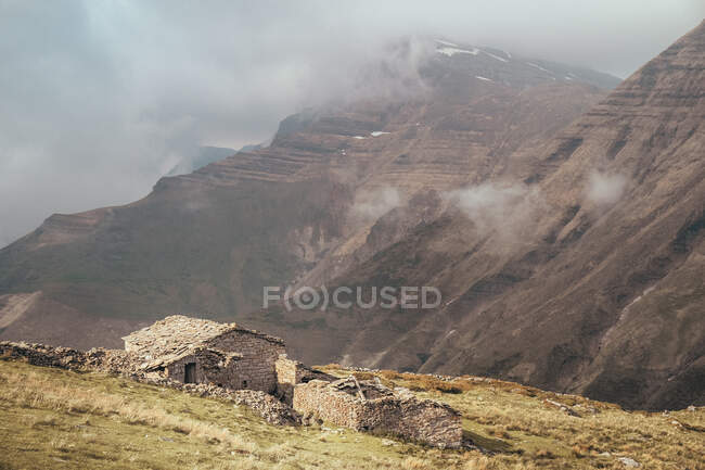 Old brick hovel near Castro Valnera mountain between clouds in Burgos, Spain — Stock Photo