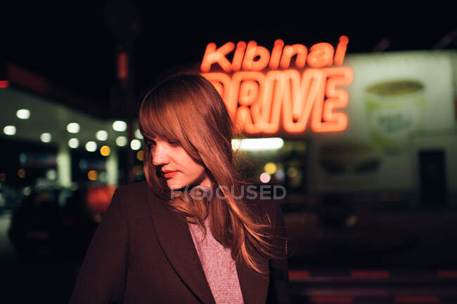 Молода жінка в пальто стоїть біля Кібіная за кермом. — стокове фото