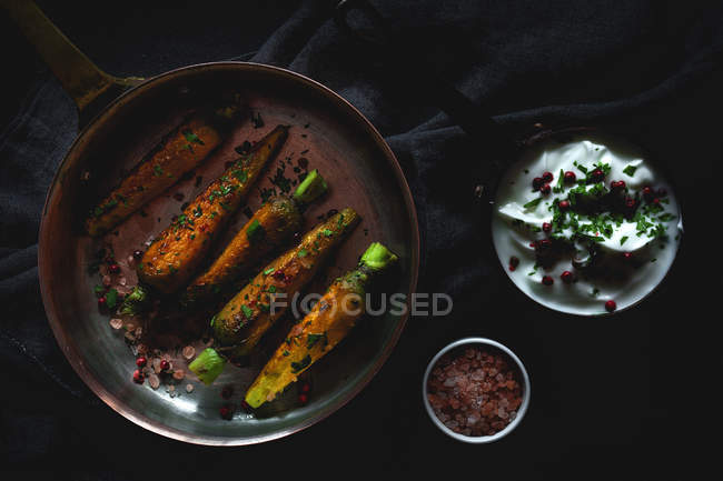 Carote arrosto sane con erbe e spezie su tessuto nero con salsa — Foto stock