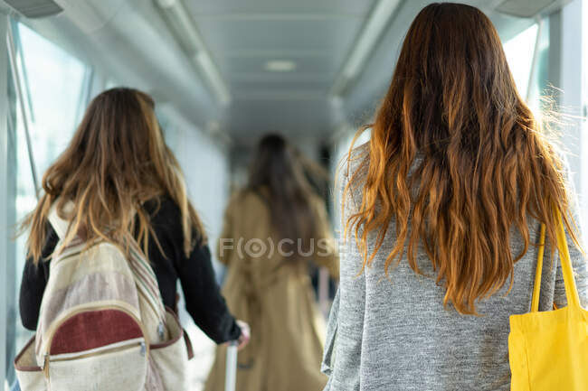 Vista posteriore signore dai capelli lunghi con borsetta e zaino in corso di passaggio in Porto, Portogallo — Foto stock