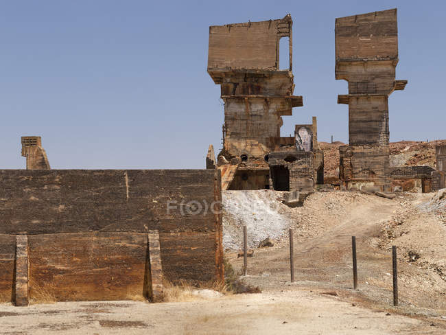 Bâtiment industriel Grungy debout au milieu de la mine de Sao Domingos par temps ensoleillé au Portugal — Photo de stock