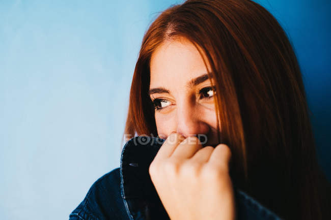 Attractive woman standing near blue wall — Stock Photo