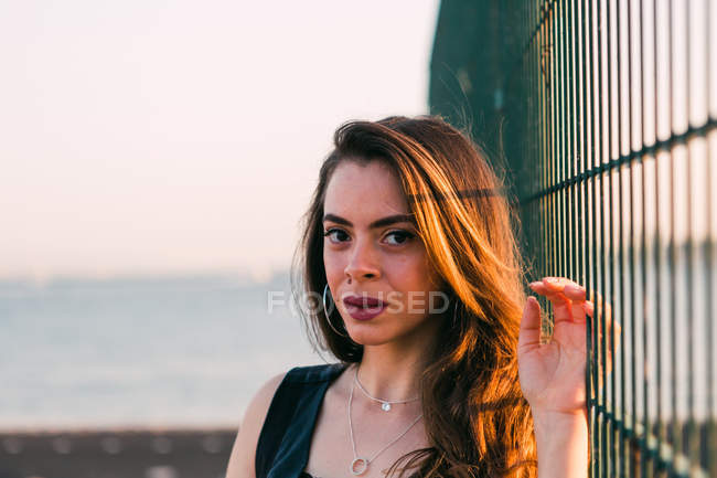 Портрет молодой привлекательной держащей решетки в солнечный день — стоковое фото
