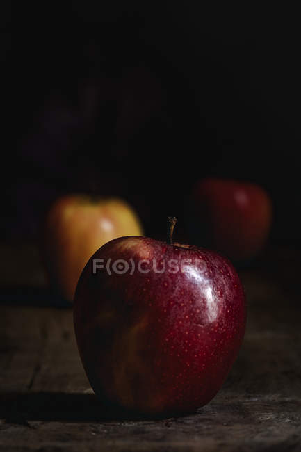 Frische Äpfel auf Holztisch auf dunklem Hintergrund — Stockfoto