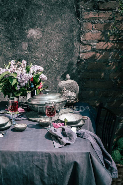 Обстановка скатертини з артишоками, квітами та червоним вином — стокове фото