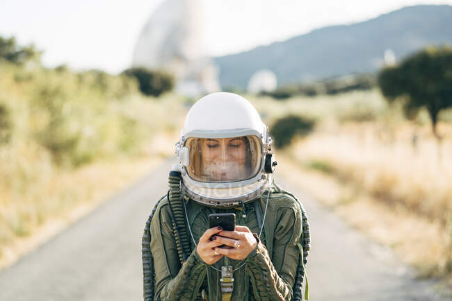 Hermosa astronauta femenina con teléfono móvil. - foto de stock