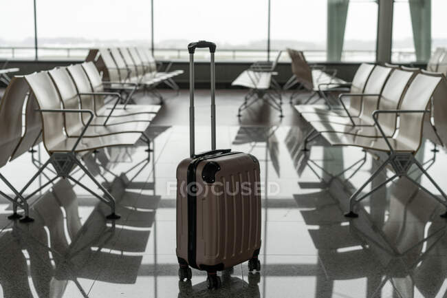 Suitcase with handle between benches — Stock Photo