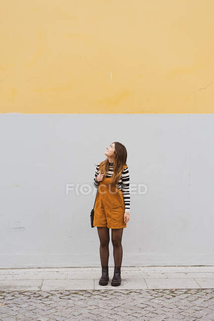 Young smiling woman near grey wall — Stock Photo