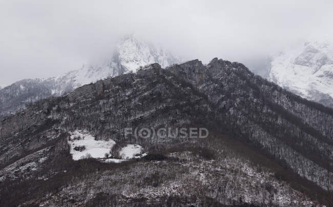 Круг темных холодных гор со снегом и дымкой — стоковое фото