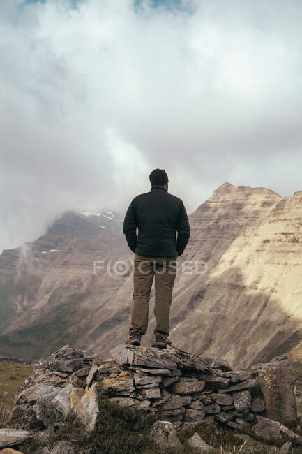 Homem em pé sobre rochas entre nevoeiro — Fotografia de Stock