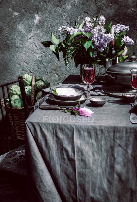 Nappe sertie d'artichauts, fleurs et vin rouge — Photo de stock