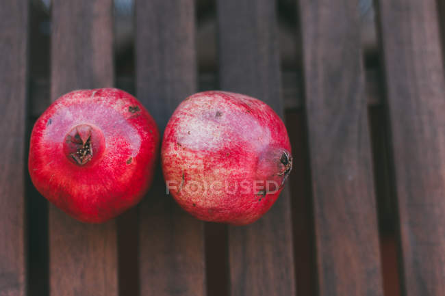 Fresh tasty red ripe pomegranates on wooden surface — Stock Photo