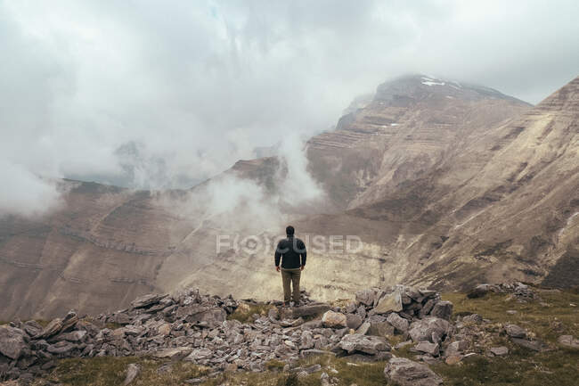 Людина стоїть на горі між туманом — стокове фото