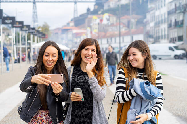 Jeunes femmes souriantes prenant selfie sur smartphone sur passerelle — Photo de stock