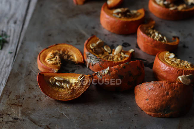 Slices of roasted pumpkin on dark surface — Stock Photo