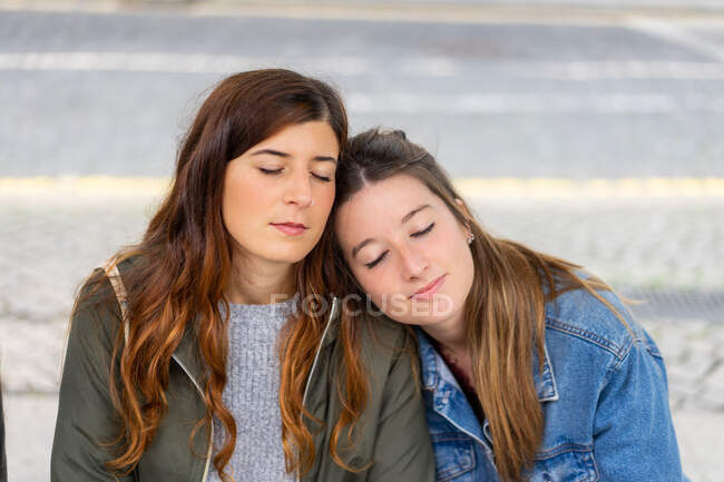 Jovens senhoras em casual desgaste sentado no banco — Fotografia de Stock