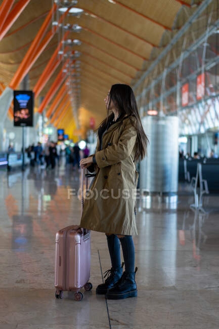 Junge Frau mit Koffer in Sitznähe — Stockfoto