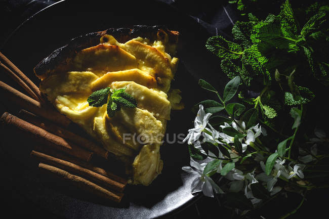 Apfelkuchen mit Zimt und Minze auf schwarzem Teller — Stockfoto