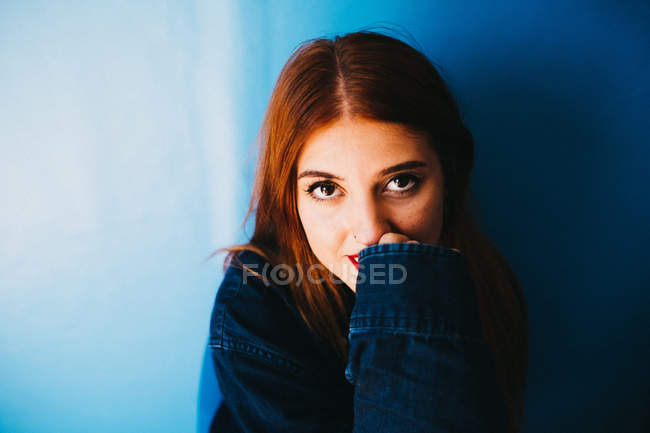 Attraktive Frau steht in der Nähe der blauen Wand — Stockfoto