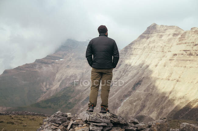 L'uomo in piedi sulla montagna tra la nebbia — Foto stock