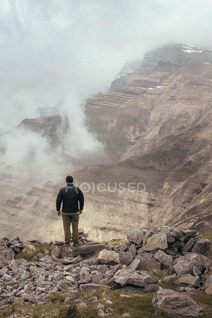 Back view male standing on Castro Valnera mountain between mist in Burgos, Spain — Stock Photo
