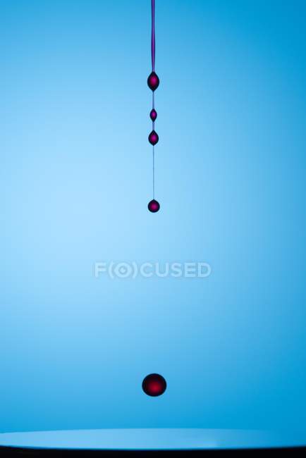 Primo piano colpo di spruzzata di liquido trasparente di colore su sfondo blu — Foto stock