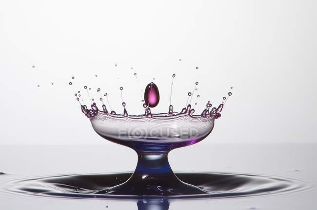 Spruzzata di liquido trasparente di colore su sfondo bianco — Foto stock