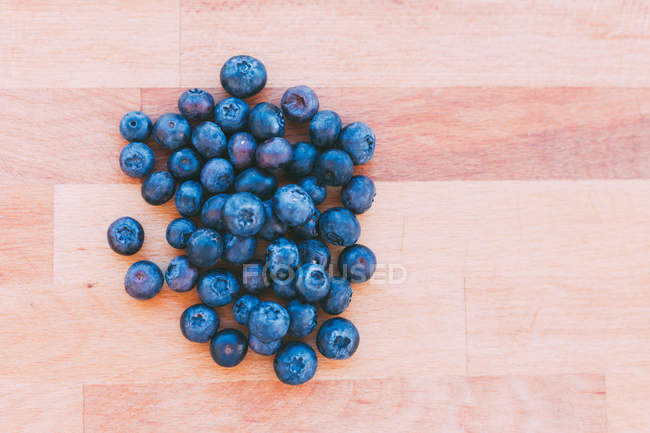 Pile of fresh tasty blueberries on wooden surface — Stock Photo