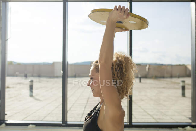 Frau trainiert mit Langhanteln in Sporthalle — Stockfoto