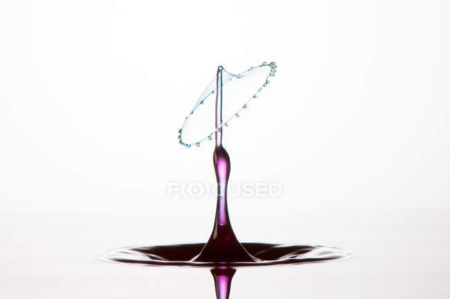 Respingo de líquido transparente de cor no fundo branco — Fotografia de Stock